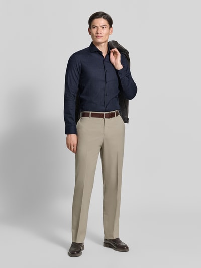 Männermodel trägt Slim Fit Businesshemd aus Baumwoll-Mix Modell 'H-HANK-SP' von BOSS in Dunkelblau, beige Hose, Ganzkörperansicht von vorne, Herren Businesshemd von BOSS.