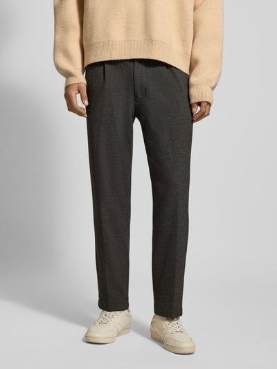 Männermodel trägt Tapered Bundfaltenhose mit Viskose-Anteil von Marc O'Polo Denim in Melange-Optik, seitliche Eingrifftaschen, Ganzkörperansicht von vorne.