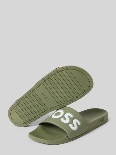 Produktfoto, Badeschuhe mit Logo Print von BOSS in Grün mit Two-Tone-Optik, flacher Absatzform, europäische Herstellung, strukturierte Oberfläche