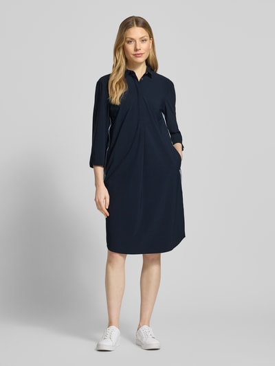 Frauenmodel trägt knielanges Hemdblusenkleid mit 3/4-Arm von WHITE LABEL aus Material-Mix mit Stretch-Anteil, gerader Schnitt, Hemdblusenkragen, Farbton Dunkelblau, glatte Struktur, Knielänge, Ganzkörperansicht von vorne.