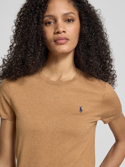 Vrouwenmodel draagt Regular Fit Kurzarmpullover aus Baumwoll-Mix van Polo Ralph Lauren in lichtbruin met logo-stitching, ronde hals, elastische mouwboorden, elastische katoenmix, nahaufnahme bovenlichaam.