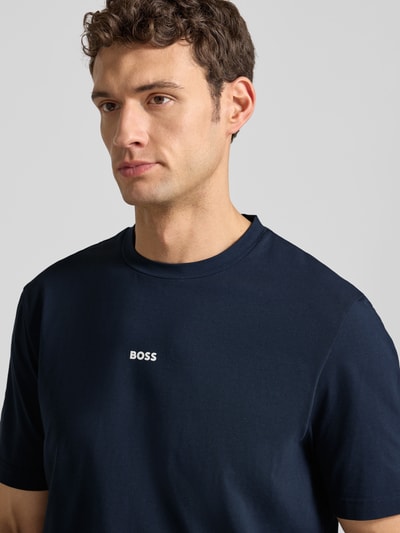 Männermodel trägt T-Shirt mit Label-Print von BOSS in Dunkelblau, Baumwoll-Elasthan-Mix, Regular-Fit, Rundhalsausschnitt, Nahaufnahme Oberkörper.