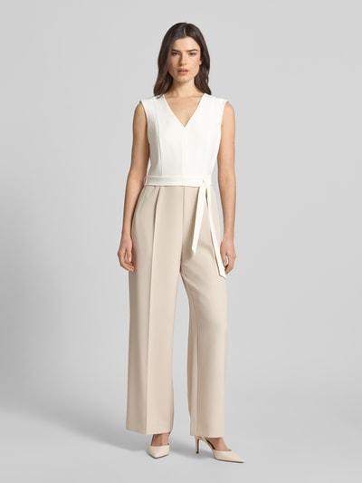 Vrouwenmodel draagt Regular Fit Jumpsuit mit Taillengürtel zum Binden van s.Oliver BLACK LABEL in two tone optiek, V-hals, zonder mouwen, brede schouderbanden, twillmateriaal, steekzakken, vooraanzicht hele lichaam.