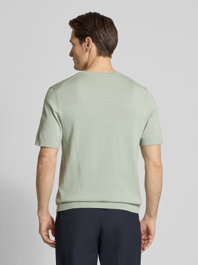 Männermodel trägt Regular Fit Strick-Shirt aus Bio-Baumwolle Modell 'TORINO' von Selected Homme, Look: effen, fijngebreid, korte mouw, ronde hals, Ganzkörperansicht Rückansicht.