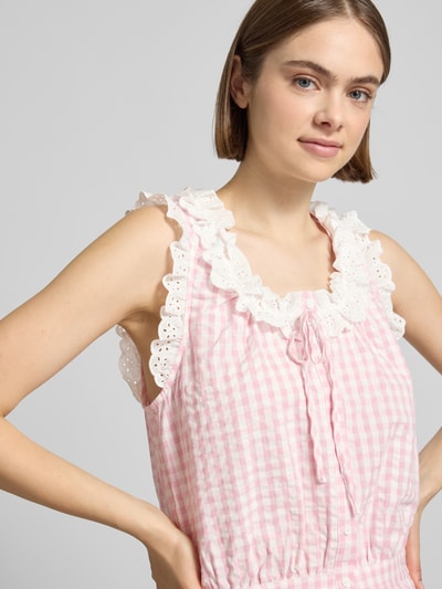 Frauenmodel trägt Cropped Blusentop mit Rüschen Modell 'Sona' von OH APRIL aus Reine Baumwolle mit Schnürung, rosa-weiß kariert, Nahaufnahme Oberkörper.