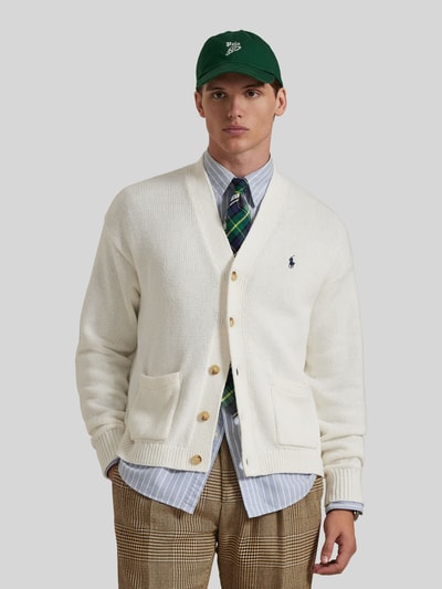 Männermodel trägt Regular Fit Strickjacke aus reiner Baumwolle von Polo Ralph Lauren, weiß, unifarben, Logo-Stitching, Ganzkörperansicht von vorne.