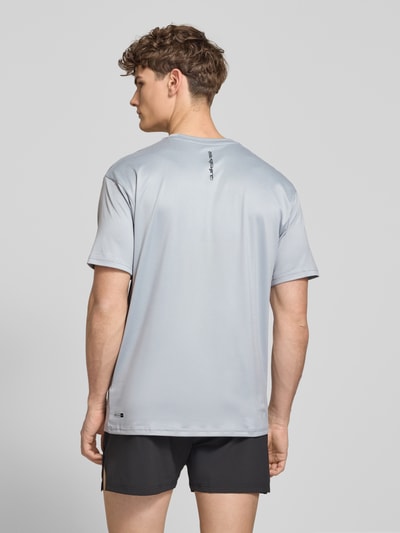 Männermodel trägt T-Shirt mit Rundhalsausschnitt und Logo von Quiksilver in Hellgrau, Regular Fit, Material-Mix mit Stretch, Ganzkörperansicht Rückansicht.