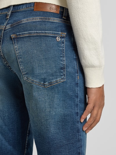Männermodel trägt Regular Fit Jeans aus Baumwoll-Mix Modell 'RE.MAINE BO' von BOSS Orange mit Denim-Optik und Label-Patch, Detailaufnahme Rückansicht.