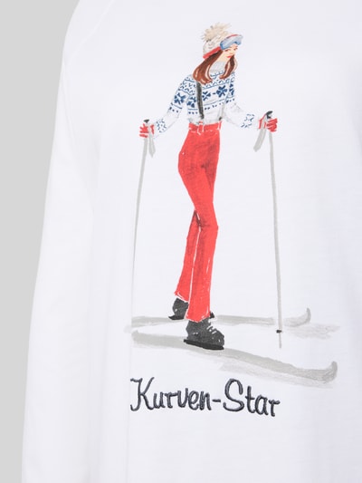 Frauenmodel trägt Nachthemd aus reiner Baumwolle Modell 'Winterzauber' von LOUIS & LOUISA, Motiv-Print auf weißem Stoff, Statement-Stitching, Raglanärmel, Rundhalsausschnitt, Nahaufnahme Oberkörper.