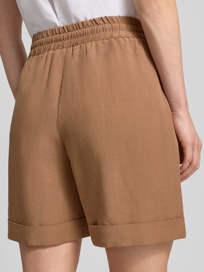 Frauenmodel trägt Regular Fit Shorts aus Viskose-Mix Modell 'Malotta' von OPUS PANTS in Hellbraun, glatte Textur, elastischer Bund, Ganzkörperansicht Rückansicht. Damen Shorts mit Leinen-Anteil, elastischer Bund mit Tunnelzug, Bundweite 40 cm, Innenbeinlänge 16 cm.