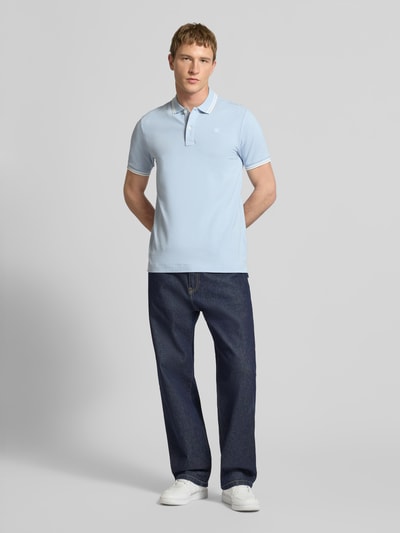 Männermodel trägt Slim Fit Poloshirt mit Logo-Stitching Modell 'Dunda' von G-Star Raw aus elastischem Baumwoll-Mix, Hellblau, Ganzkörperansicht von vorne.