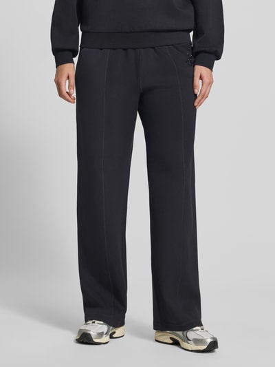 Mannelijk model draagt Wide Fit broek uit viscosemix met elastische band en steekzakken van Liu Jo, zwart, detailopname benen.