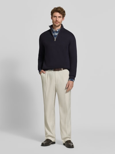 Männermodel trägt Slim Fit Pullover aus reiner Baumwolle Modell 'MILANO' von JACK & JONES Premium in Dunkelblau, Strick-Optik, Ganzkörperansicht von vorne.