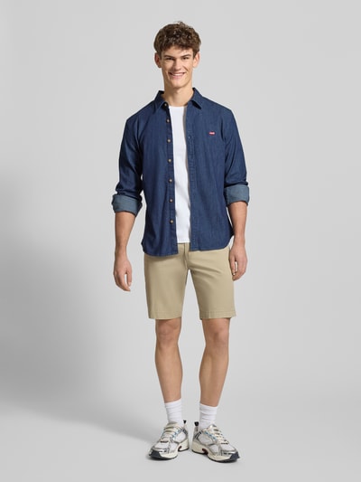Männermodel trägt T-Shirt mit Label-Stitching von Levi's®, Herren T-Shirt aus reiner Baumwolle im Regular-Fit mit geripptem Rundhalsausschnitt, Rückenlänge bei Größe M 69 cm, Ganzkörperansicht von vorne.