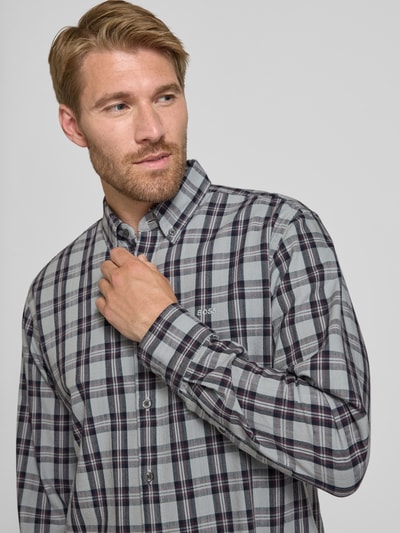 Mężczyzna model nosi Regular Fit koszula casualowa z mieszanki bawełny i wiskozy model 'Ricoplus_M' od BOSS Orange, wzór w kratę, szaro-czarna, widok na górną część ciała z przodu.