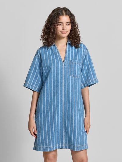 Frauenmodel trägt Relaxed Fit Jeanskleid aus reiner Baumwolle - Special Drop von Marc O'Polo Denim im gestreiften Denim-Look, Mini-Länge, V-Ausschnitt, Hemdblusenkragen, Optik: Denim, Passform: Relaxed-Fit, Muster: Gestreift, Material: Baumwolle, Ganzkörperansicht von vorne.