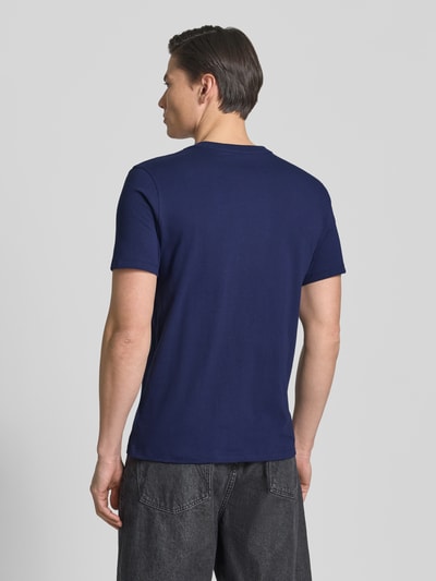 Männermodel trägt T-Shirt mit Rundhalsausschnitt und Label-Stitching von GAP in Dunkelblau, Reine Baumwolle, Regular-Fit, Ganzkörperansicht Rückansicht. Rückenlänge bei Größe M: 69 cm.