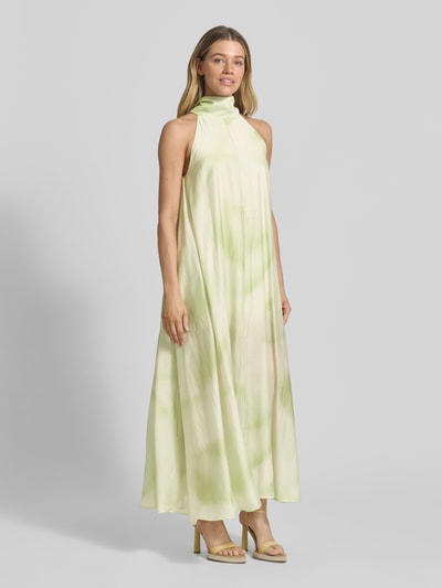 Frauenmodel trägt Neckholder-Maxikleid aus Lyocell-Mix Modell 'FIE' von Copenhagen Muse in hellgrün-creme mit A-Linie, Ganzkörperansicht von vorne.