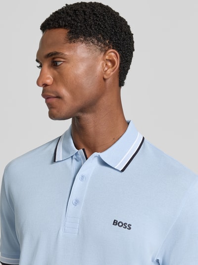 Männermodel trägt Regular Fit Poloshirt mit Label-Stitching Modell 'Paddy' von BOSS, reine Baumwolle, hellblau, Nahaufnahme Oberkörper.