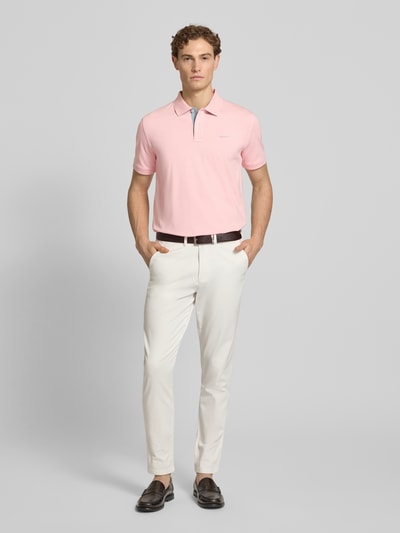 Mannelijk model draagt Regular Fit Poloshirt met Logo-Stitching van Gant, elastische katoenmix, polokraag, korte mouwen, lichtroze, volledige lichaamsvoorzijde.