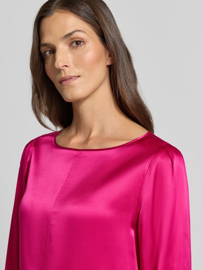 Frauenmodel trägt Regular Fit Bluse aus Seide mit 3/4-Arm von Marc Cain in kräftigem Pink, seidige Oberfläche, Nahaufnahme Oberkörper. Reine Seide, Rundhalsausschnitt, Rückenlänge 59 cm, Ärmellänge 49 cm.