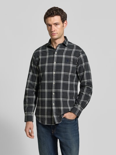 Männermodel trägt Regular Fit Freizeithemd aus reiner Baumwolle von Polo Ralph Lauren in Schwarz mit Karomuster, Ganzkörperansicht von vorne.