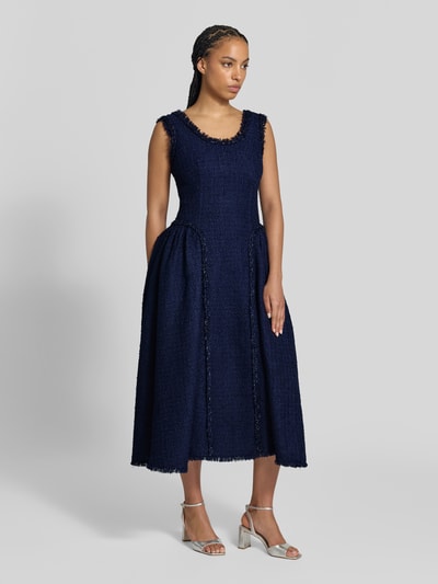 Frauenmodel trägt Midikleid mit Woll-Anteil von Self-Portrait, dunkelblauer Bouclé-Stoff, taillierte Passform, Ganzkörperansicht von vorne.