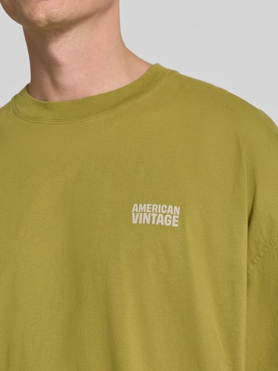 Männermodel trägt T-Shirt mit Logo-Print Modell 'GIXY' von American Vintage, olivgrün, reine Baumwolle, Nahaufnahme Oberkörper.