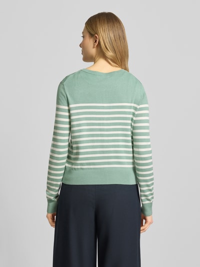 Frauenmodel trägt Strickjacke aus Viskose-Mix mit Streifenmuster von Christian Berg Woman, Rundhalsausschnitt, Knopfleiste, Regular-Fit, Rückenlänge bei Größe S 49 cm, Ärmellänge 61 cm, sanfte Grüntöne und Weiß, Ganzkörperansicht Rückansicht.