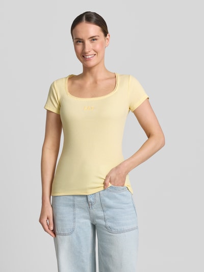 Frauenmodel trägt T-Shirt mit Logo-Stitching von GAP aus gelbem Baumwoll-Mix mit Stretch-Anteil, körpernahe Passform, Rundhalsausschnitt, Rückenlänge bei Größe S 57 cm, Ganzkörperansicht von vorne.