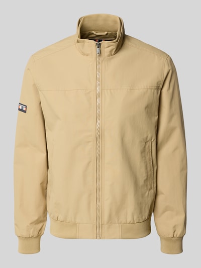 Produktfoto, kurtka 'Jacke mit Stehkragen und Eingrifftaschen' od Superdry, beżowa, krój regular fit, stójka, zamek błyskawiczny, wpuszczane kieszenie, długość tyłu w rozmiarze M: 70 cm, szerokość ramion w rozmiarze M: 44 cm, szerokość klatki piersiowej w rozmiarze M: 41 cm, długość rękawów w rozmiarze M: 68 cm