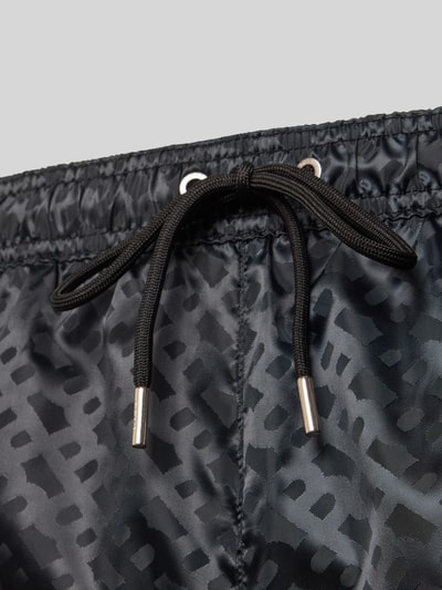 Produktfoto, Regular Fit Badeshorts mit Tunnelzug Modell 'JACQUES' von BOSS in Schwarz, unifarbene Satin-Struktur, Logo-Muster, Detailaufnahme