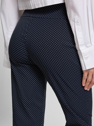 Frauenmodel trägt Hose aus Viskose-Mix mit elastischem Bund Modell 'Ina' von STEHMANN, dunkelblau mit weißen Punkten, Nahaufnahme Rückansicht, verkürzte Passform, stretchig, Innenbeinlänge 93 cm bei Größe 36.