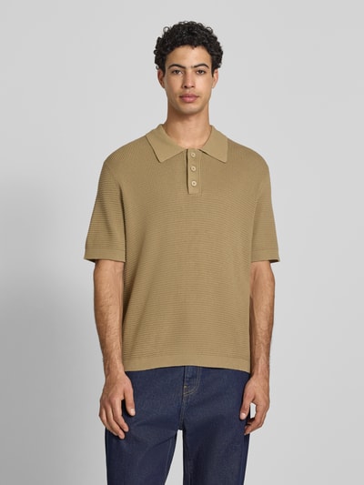 Männermodel trägt Regular Fit Poloshirt aus reiner Baumwolle von Marc O'Polo Denim, Optik: Unifarben, Strick, Label-Patch, Ganzkörperansicht von vorne.