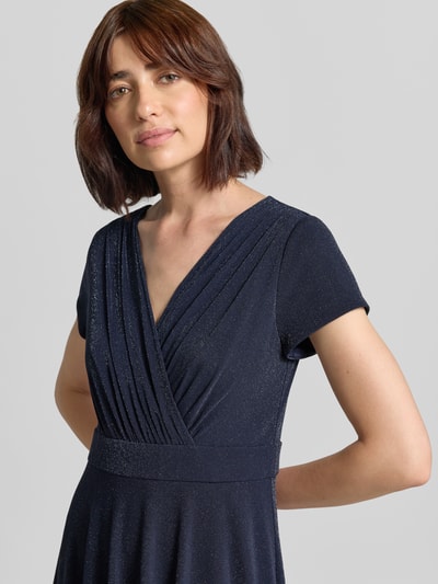 Frauenmodel trägt Tailliertes Cocktailkleid mit V-Ausschnitt von Vera Mont in Dunkelblau mit leichter Glitzerstruktur, Nahaufnahme Oberkörper.