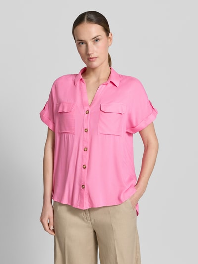 Frauenmodel trägt Regular Fit Hemdbluse aus reiner Viskose Modell 'BUMPY' von Vero Moda in Pink, kurzarm, zwei Brusttaschen, Ganzkörperansicht von vorne.