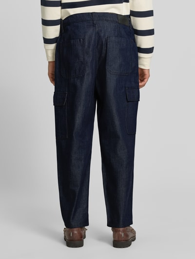 Männermodel trägt dunkelblaue Tapered Fit Jeans aus Baumwoll-Lyocell-Mix Modell 'Isak' von Marc O'Polo DENIM, lockere Passform, Ganzkörperansicht Rückansicht.