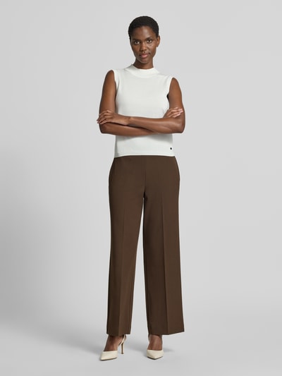 Frauenmodel trägt Regular Fit Weite Hose mit Viskose-Anteil Modell 'EMMA-TARA' von Selected, braun, kombiniert mit weißem Top, Ganzkörperansicht von vorne, Damen Weite Hose von Selected.