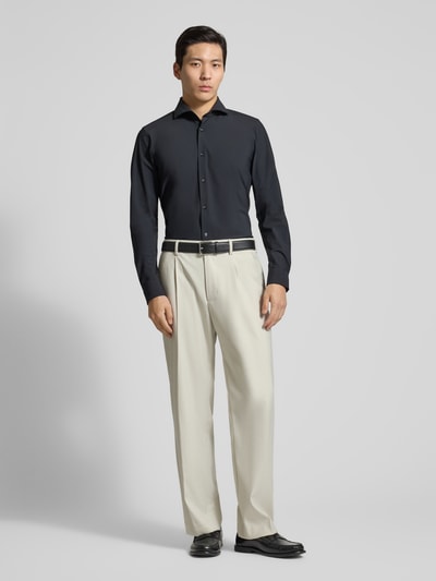 Männermodel trägt Slim Fit Business-Hemd mit Kentkragen von JOOP! Collection in Schwarz, glatte Struktur, Ganzkörperansicht von vorne. Material-Mix mit Stretch-Anteil, Knopfleiste, langärmelig, Sportmanschetten, abgerundeter Saum.