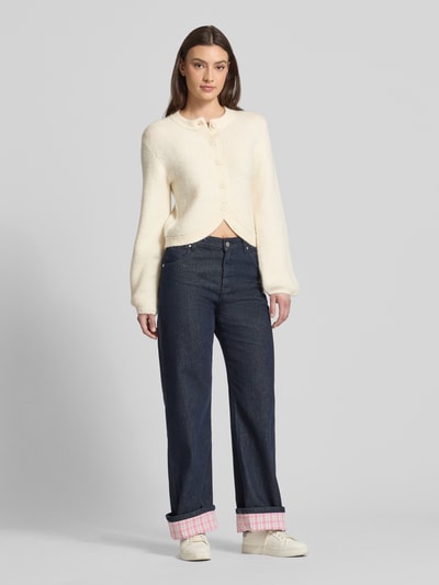 Frauenmodel trägt Strickjacke mit Rundhalsausschnitt Modell 'Ally' von Gina Tricot im Material-Mix mit Alpaka-Anteil, Regular-Fit, Knopfleiste, Farbe Creme, zu sehen in Ganzkörperansicht von vorne.