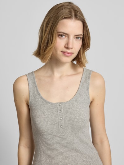 Frauenmodel trägt Slim Fit Tank Top aus Bio-Baumwoll-Mix Modell 'KITTE' von Pieces, Optik: Unifarben, Knopf-Detail, Henley-Ausschnitt, breite Träger, Materialverarbeitung: Ripp, Nahaufnahme Oberkörper.