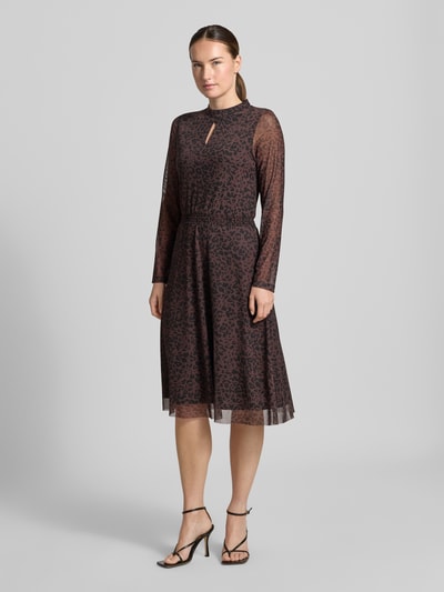 Frauenmodel trägt Knielanges Kleid mit Stretch-Anteil von MORE & MORE mit Cut Out, Stehkragen, semitransparent langärmelig, Ganzkörperansicht von vorne.