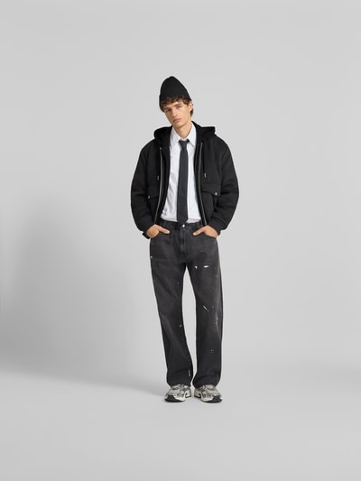 Männermodel trägt Jacke mit Kapuze von Moose Knuckles in Schwarz, Regular Fit, Woll-Mix, Frontreißverschluss, Pattentaschen, Ganzkörperansicht von vorne.