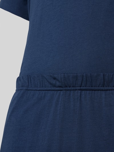 Männermodel trägt Pyjama mit Logo von Schiesser in Dunkelblau, Baumwoll-Micromodal-Mix, elastischer Bund, Nahaufnahme Oberkörper.