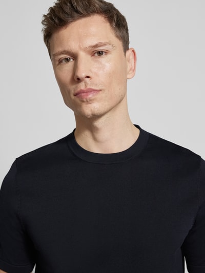 Männermodel trägt Slim Fit T-Shirt aus reiner Baumwolle von Profuomo, schlichtes Schwarz, Rundhalsausschnitt, Nahaufnahme Oberkörper.