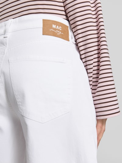 Frauenmodel trägt weiße Jeans mit Fransen Modell 'Nevada' von MAC aus Baumwoll-Mix mit Stretch-Anteil, Nahaufnahme Rückansicht.