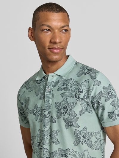 Männermodel trägt Slim Fit Poloshirt mit floralem Allover-Print von Lerros aus Reine Baumwolle, Polokragen, Kurzärmelig, Nahaufnahme Oberkörper.