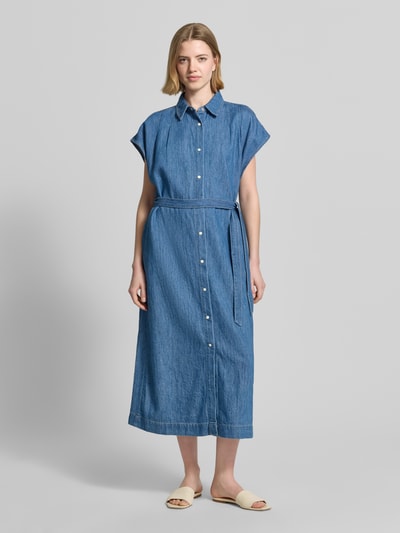 Frauenmodel trägt Regular Fit Jeanskleid aus reiner Baumwolle von s.Oliver RED LABEL in mittlerem Blau mit Kontrastnähten, Midi-Länge, Bindegürtel, hochgeschlossenem Ausschnitt und kurzen Ärmeln, Ganzkörperansicht von vorne.