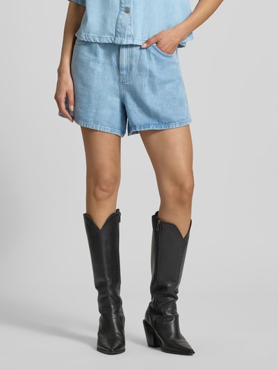 Frauenmodel trägt Straight Fit Shorts aus reinem Lyocell Modell 'Saphina' von MSCH Copenhagen, Denim-Optik, Eingriffstaschen, Ganzkörperansicht von vorne.