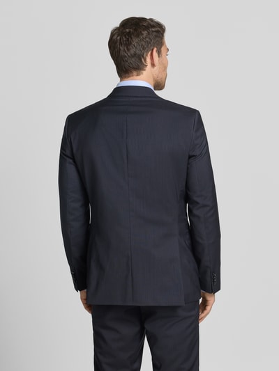 Männermodel trägt Slim Fit Anzugsakko aus reiner Schurwolle Modell 'H-HUGE-263' von BOSS, dunkelblau, Nadelstreifen-Muster, Ganzkörperansicht Rückansicht.